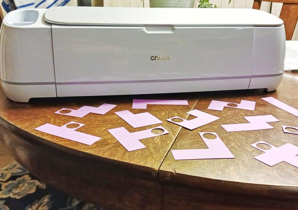 2024 pentomino puzzle pieces with holes in them sitting in front of cricut maker 3 machine. 