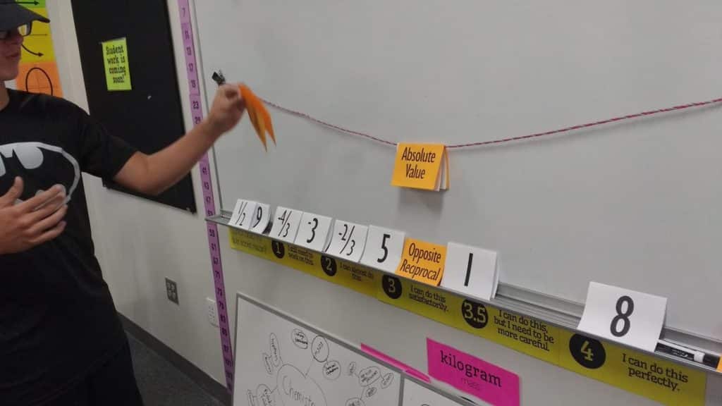 student placing card on clothesline. 