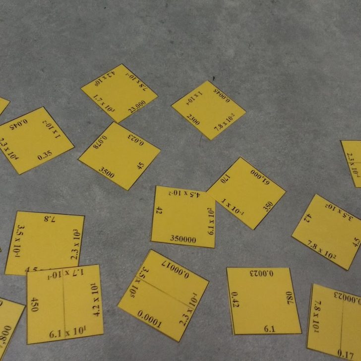 scientific notation square puzzle scatterd on desk.