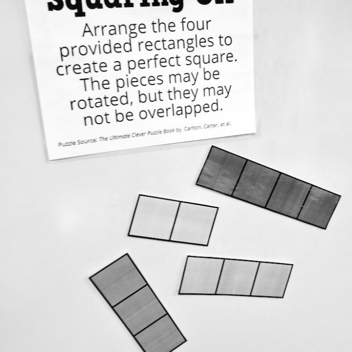 squaring off puzzle hanging on dry erase board in classroom.